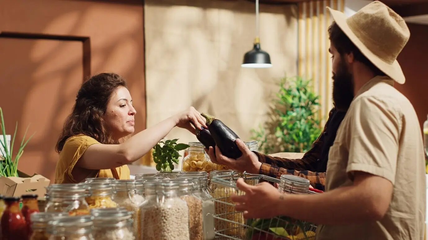 Ein älterer Ladeninhaber unterstützt Kunden.