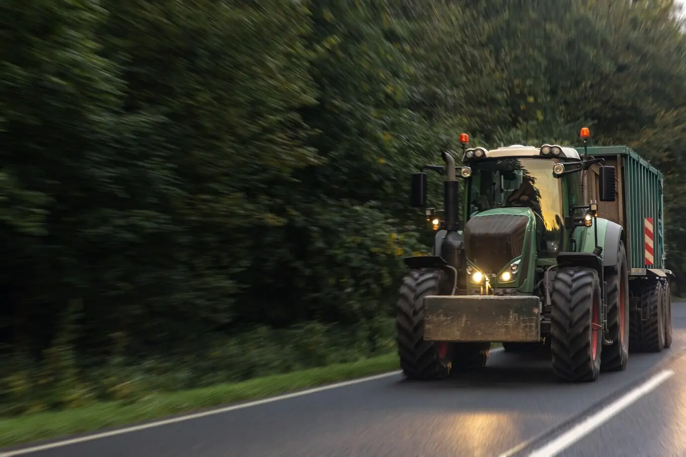 Moderner Traktor auf einer ländlichen Straße, Landwirtschaft in Bewegung.